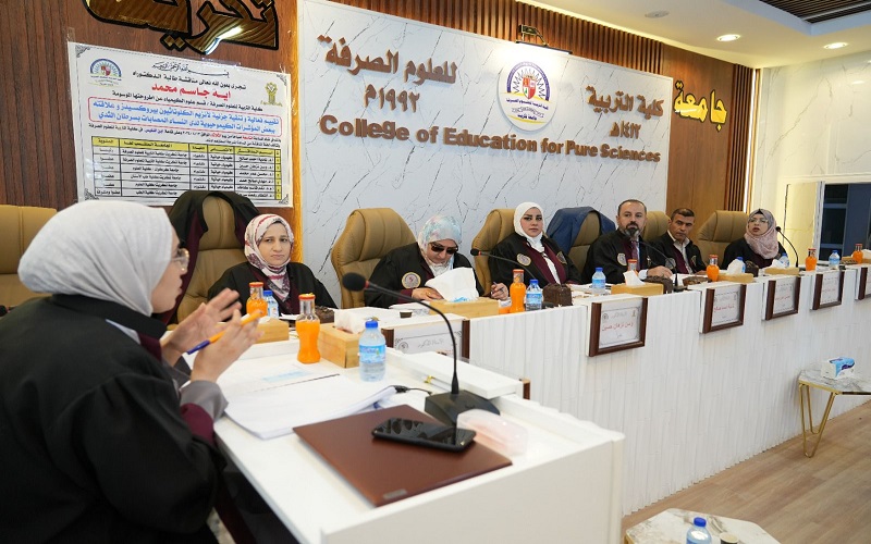 Assistant Dean of the College of Science for Scientific Affairs examines a PhD student