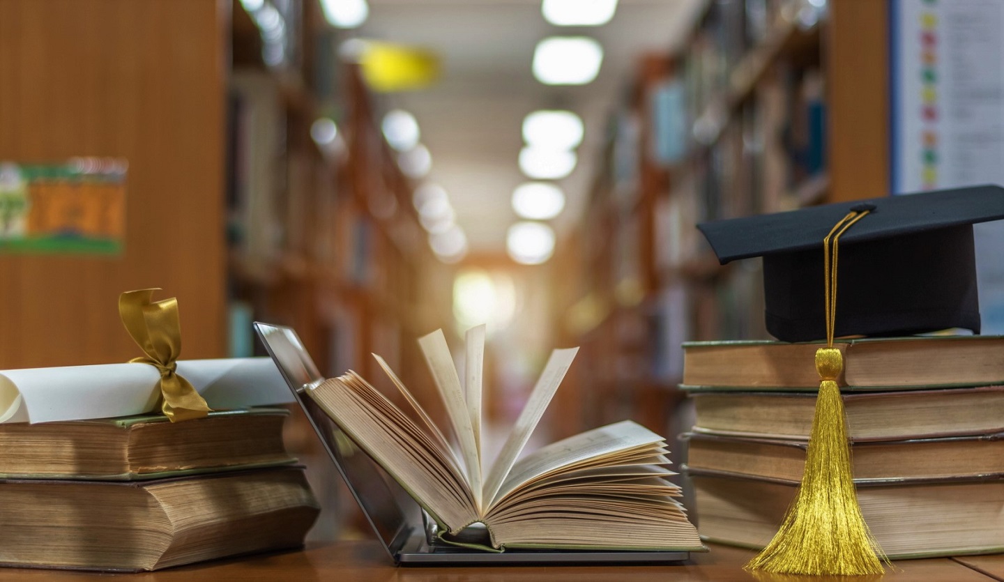 Online education course, E-learning class and e-book digital technology concept with pc computer notebook open in blur school library or classroom background among old stacks of book, textbook  (Online education course, E-learning class and e-book dig