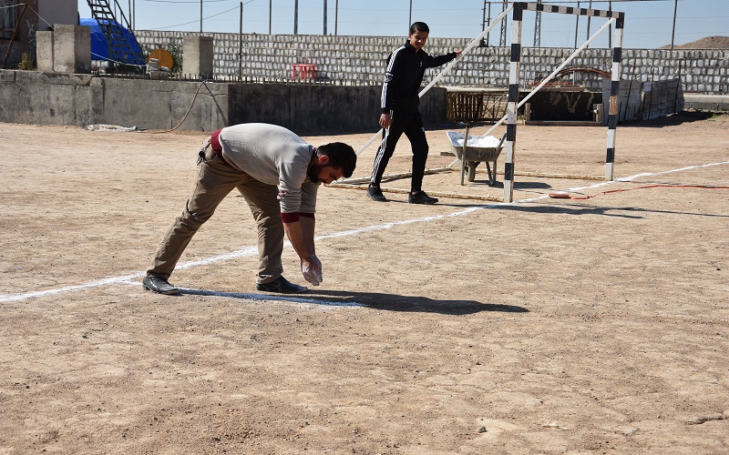 كلية التربية البدنية وعلوم الرياضة تنظم حملة تطوعية لتخطيط ملعب لكرة القدم الخماسي
