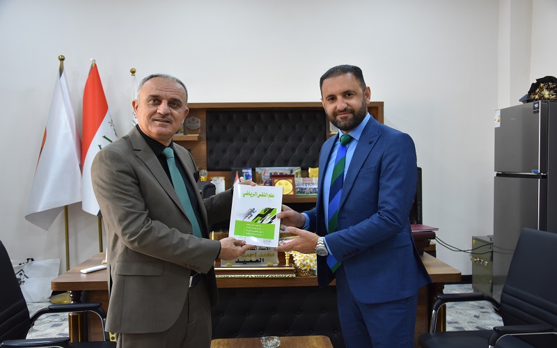 تدريسي يهدي أحد مؤلفاته العلمية لمكتبة كلية التربية البدنية وعلوم الرياضة